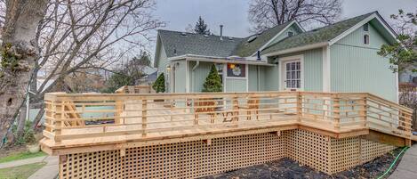 A house with a wooden deck and a green roof.