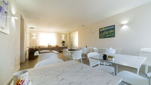 A modern dining area with white furniture and a marble table. - Garda Room (Peschiera del Garda)