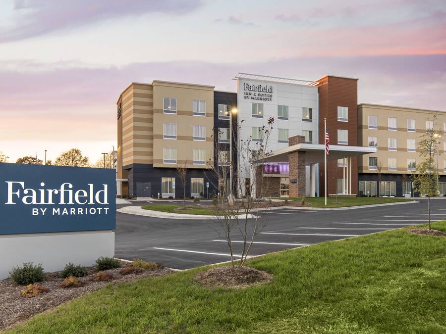 A Marriott Fairfield hotel with a modern design, featuring a large sign, multiple floors, and a parking lot.