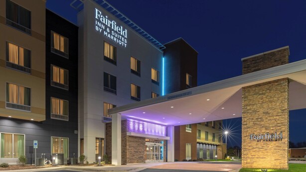 Un hotel Marriott Fairfield con fachada moderna, grandes ventanales y una entrada bien iluminada.