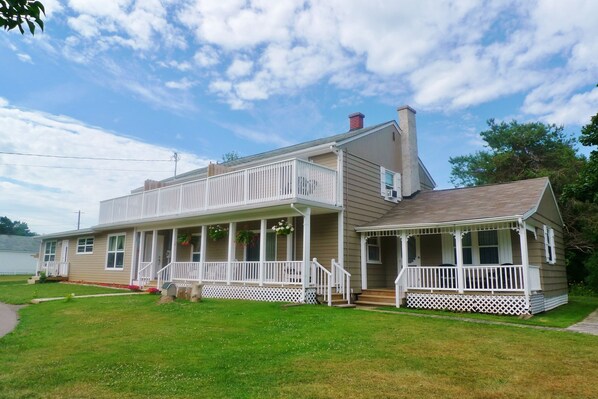 A two-story house with a porch, a chimney, and a well-maintained lawn.
