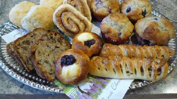 A variety of baked goods on a tray, including muffins, scones, and a pastry with a lattice crust.