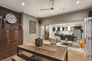 A modern kitchen with a central island, a dining area with a wooden table, and a ceiling fan.