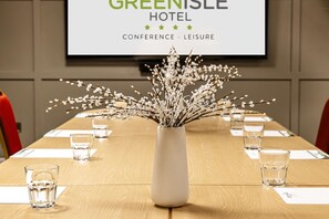 A conference table with a white vase of white flowers, water glasses, and a sign for the Green Isle Hotel. - The Green Isle Hotel Dublin (Dublin)