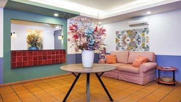 A reception area with a round table, a sofa, and a wall-mounted artwork.