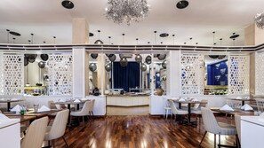 Un restaurant doté d’un bar central, d’un plancher en bois et de luminaires décoratifs au plafond.