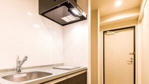 A modern bathroom with a stainless steel sink, a mirror, and a toilet. - Mr.KINJO in SAKAEMACHI (Naha)