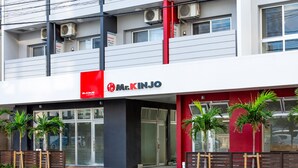 A modern building with a prominent red and white facade, featuring a sign for 'Mr. KINJO'. - Mr.KINJO in SAKAEMACHI (Naha)