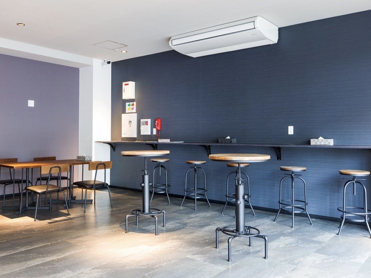 A modern bar area with high stools and a long counter.