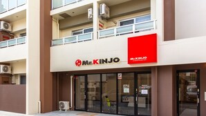 Ein zweistöckiges Gebäude mit einer Schaufensterschild, auf dem "Mr. Kinjo" steht.