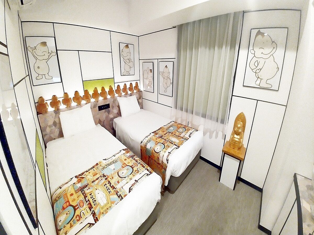Ein Hotelzimmer mit zwei Betten, einem kleinen Tisch und einem Stuhl.