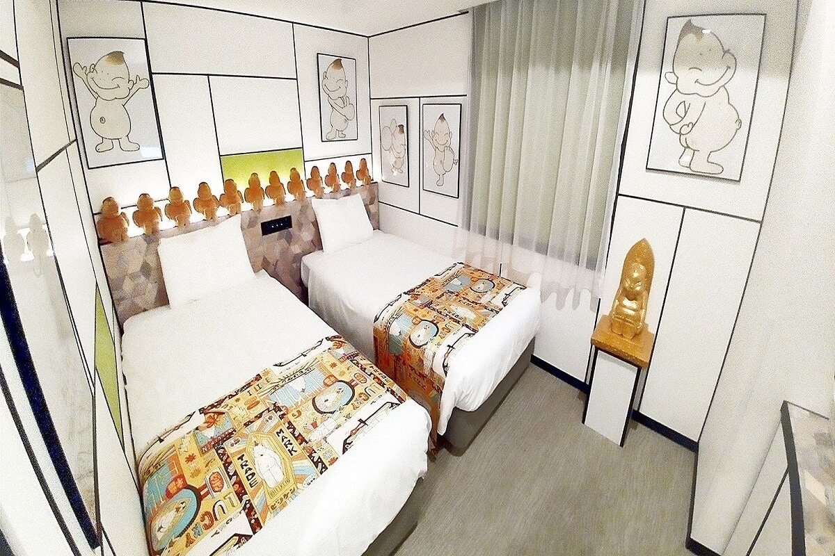 Une chambre d’hôtel avec deux lits, une petite table et une chaise.