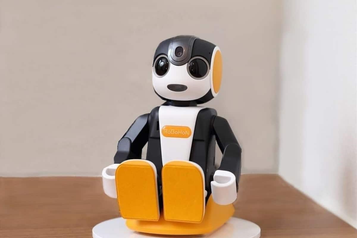 Un robot RoBoHoN sentado sobre una base blanca.