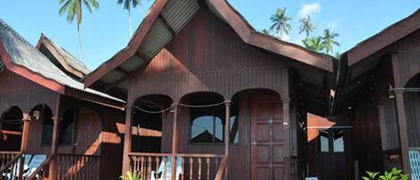 A traditional wooden building with a porch and multiple windows.