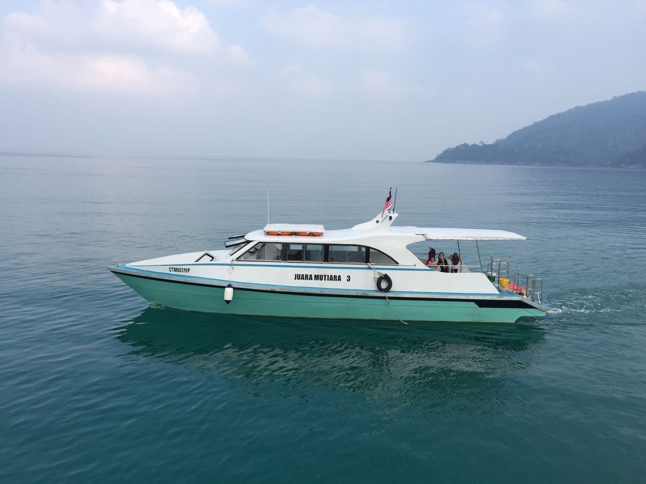 Ein Boot namens 'JUARA MUTIARA 3' auf ruhigem Wasser.
