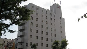 Un edificio de varios pisos con fachada uniforme, numerosas ventanas y techo plano.
