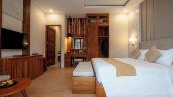 A modern hotel room with a large bed, a desk, a television, and a wardrobe.