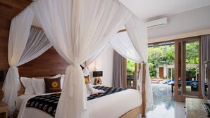 A spacious bedroom with a large bed, a canopy, and a view of the garden. - Freddies Resort & Villas Ubud (Ubud)
