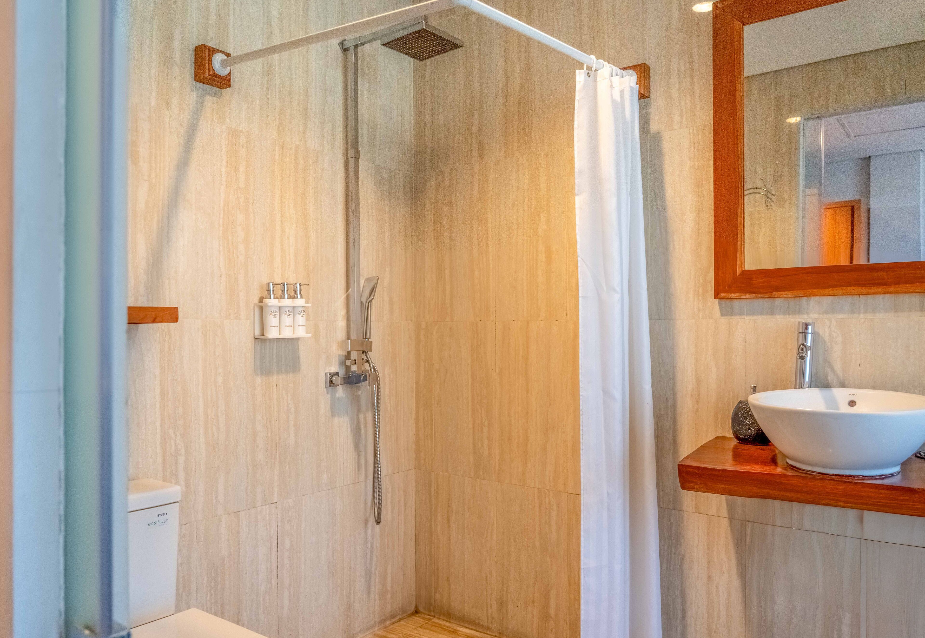 Un baño moderno con ducha, inodoro y lavamanos.