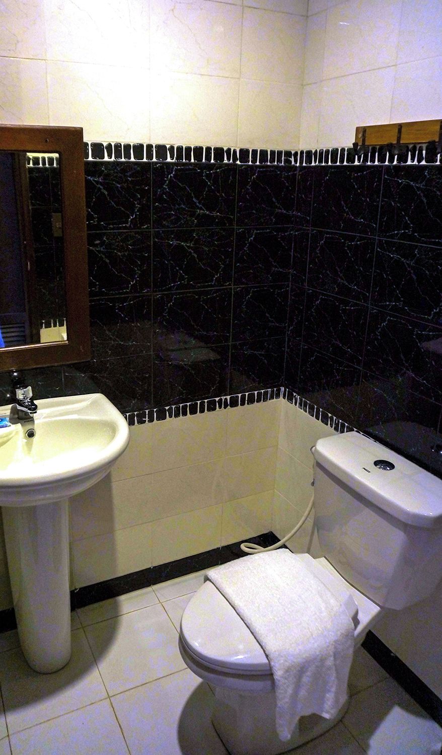A bathroom with a white sink, a toilet, and a mirror.