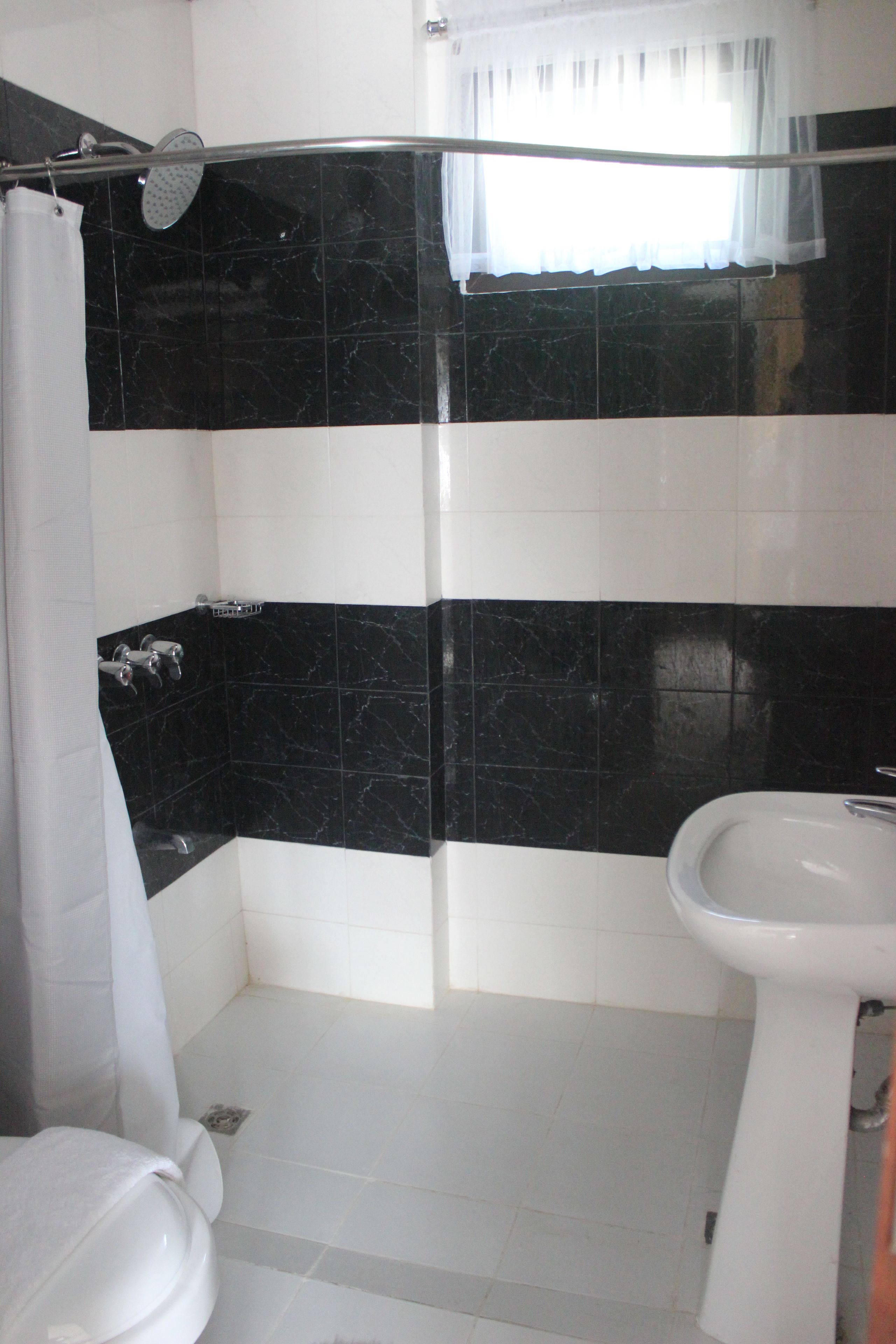 Un baño con ducha, inodoro y lavamanos.