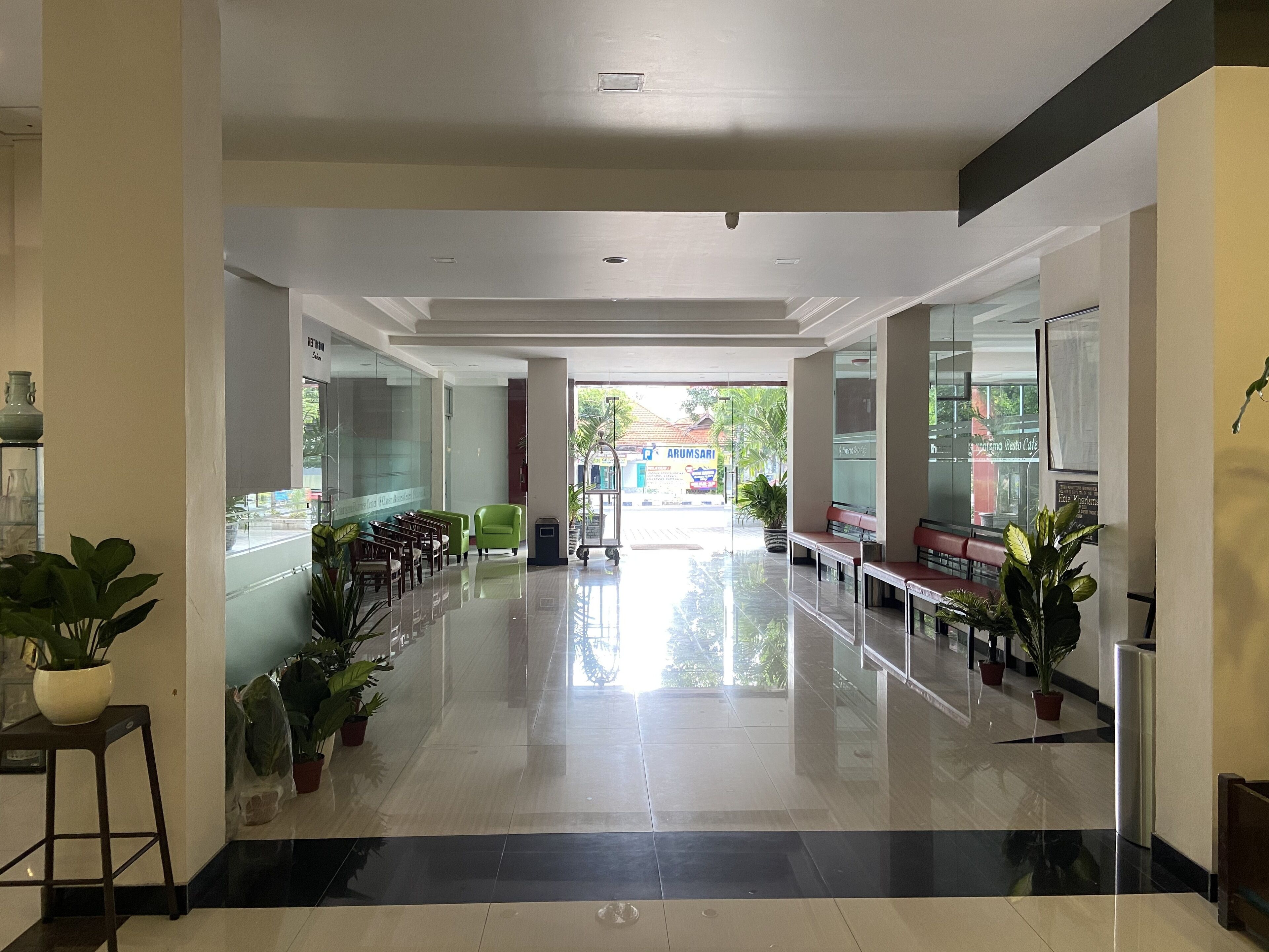 Eine saubere, moderne Lobby mit glänzend gefliestem Boden, Sitzbereichen und Topfpflanzen.