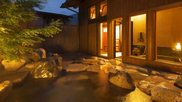 A wooden building with a stone pathway leading to a wooden door. - Yamaboushi (Takayama)