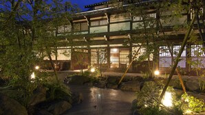 A traditional Japanese building with a wooden structure and a garden with rocks and plants. - Yamaboushi (Takayama)