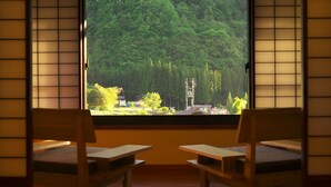 A room with tatami mat flooring, a large window with a view of a forest, and two wooden benches. - Yamaboushi (Takayama)
