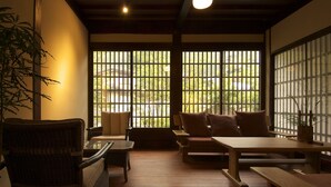 A traditional Japanese room with tatami flooring, a low wooden table, and a cushioned seating area. - Yamaboushi (Takayama)