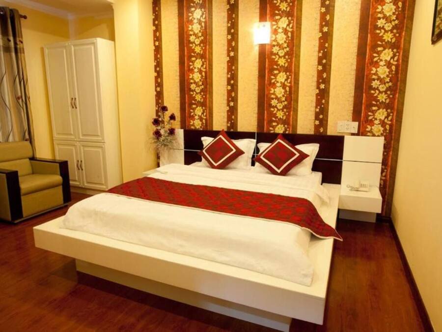 A bedroom with a bed, a chair, a nightstand, and a wardrobe.