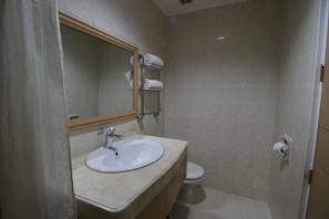 Une salle de bain équipée d’un lavabo, d’un miroir, d’un porte-serviettes et de toilettes.