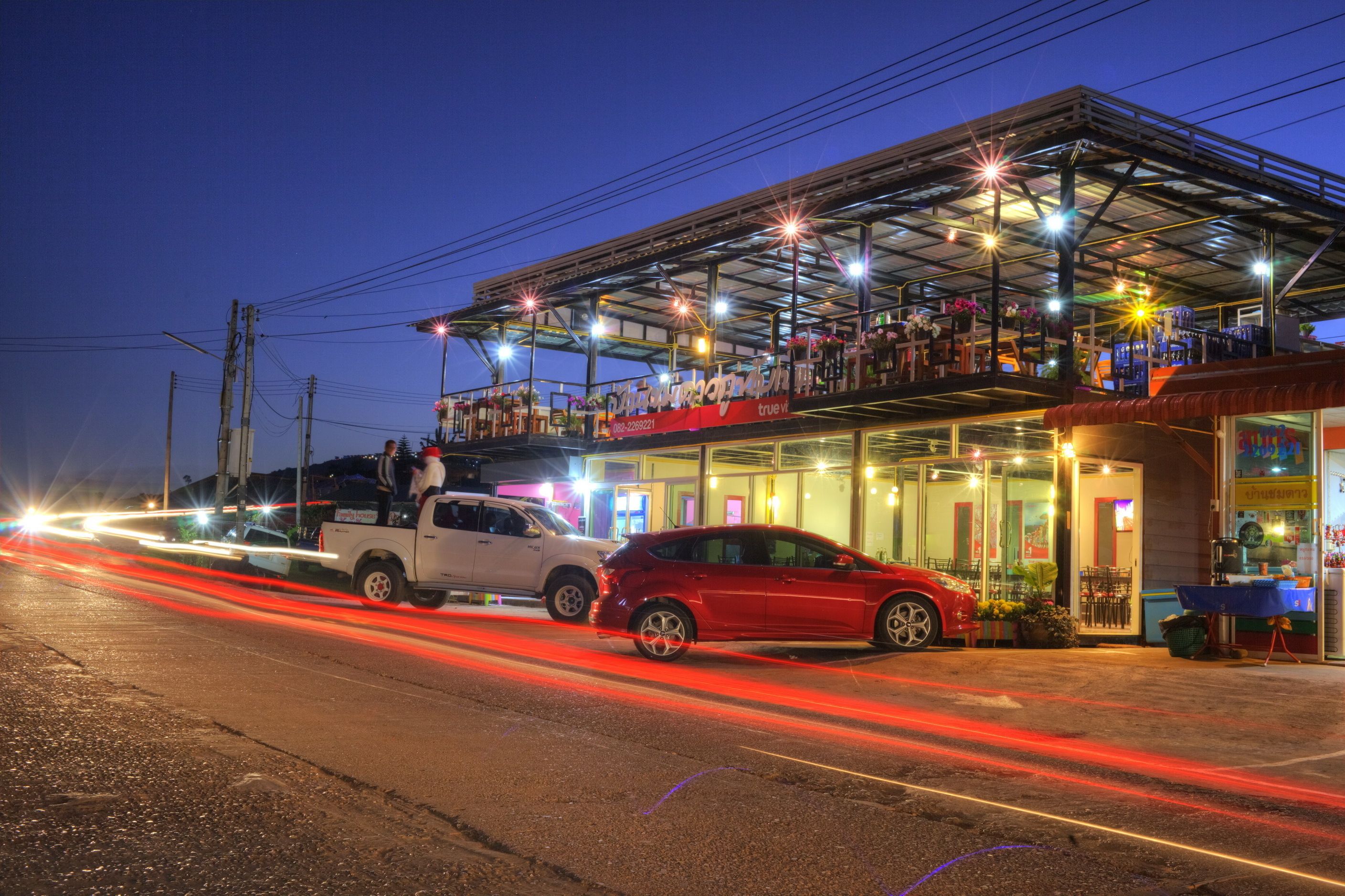 A building with a covered outdoor seating area and a storefront.