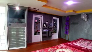 Un dormitorio con cama, armario, escritorio con silla y ventana.