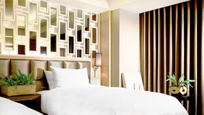 A hotel room with two beds, a decorative wall, a nightstand with a lamp, and a window with vertical blinds. - Royal Group Hotel Chang Chien Branch (Kaohsiung)