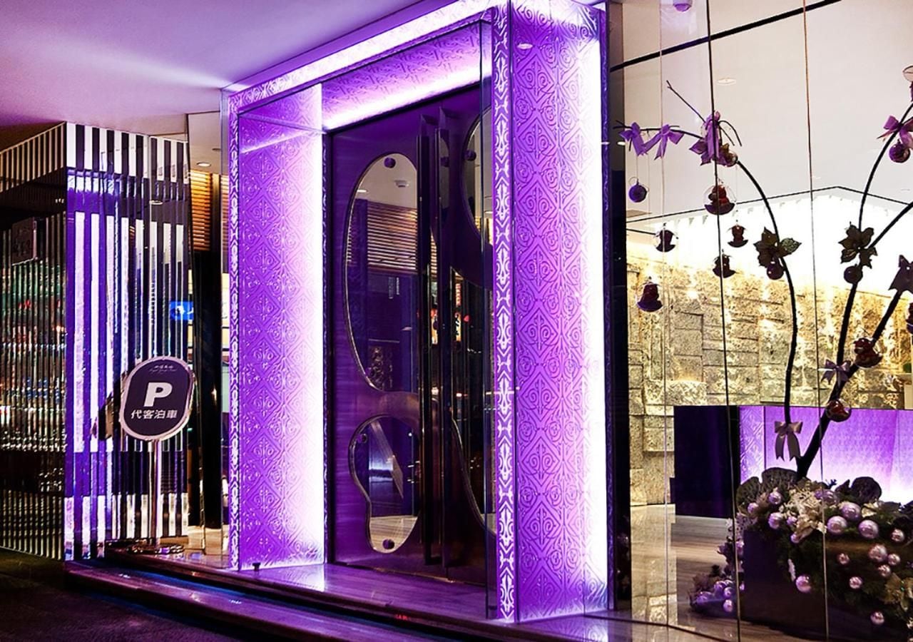 A hotel entrance with a modern design, including a glass door and a decorative wall with a pattern.