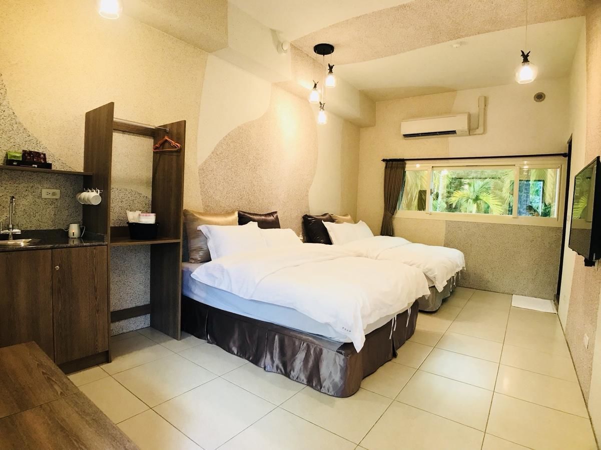 Habitación de hotel con cama, escritorio, espejo y ventana con vista a la vegetación.