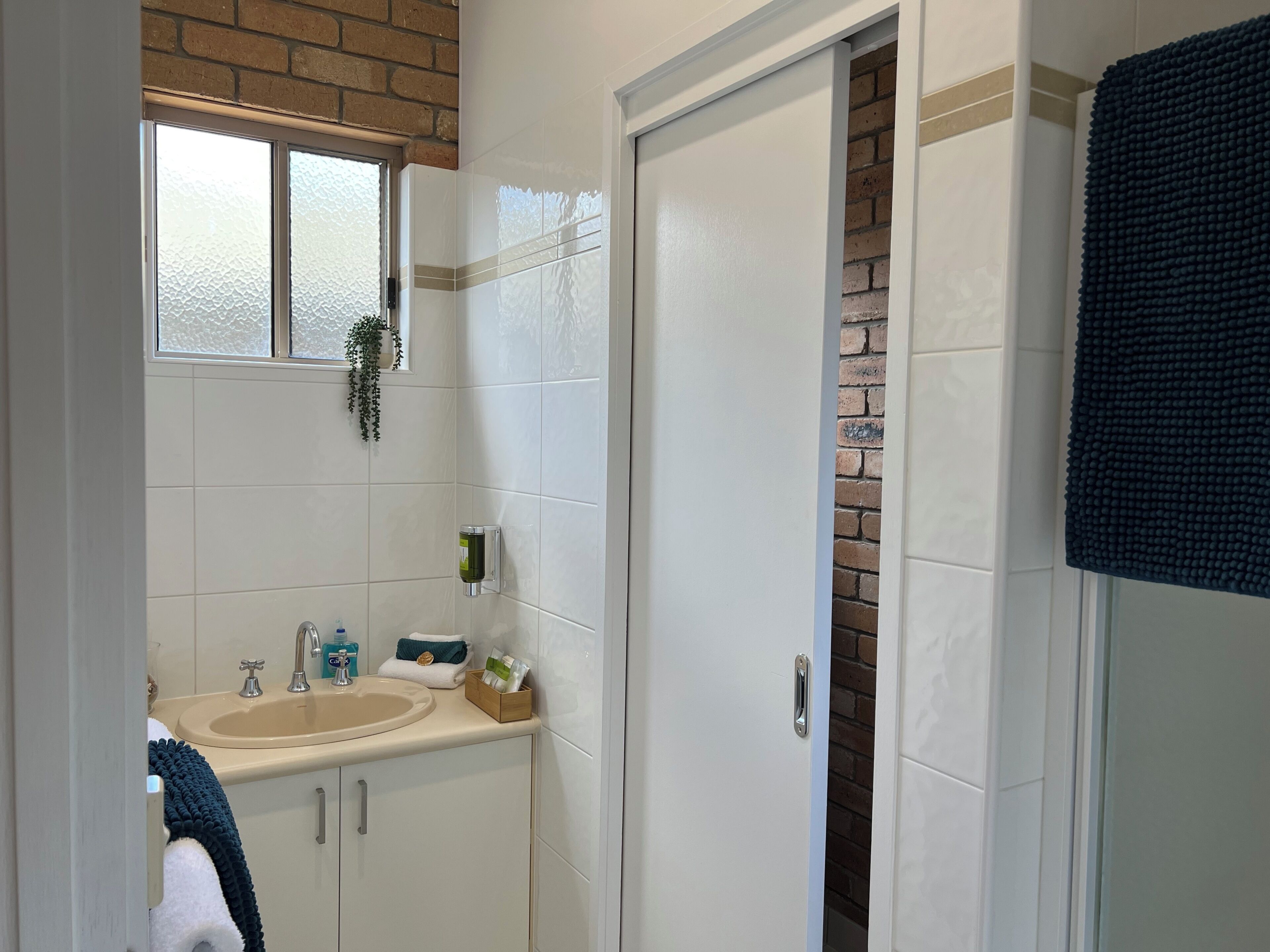 Une salle de bain équipée d’un lavabo, d’un miroir et d’un porte-serviettes.