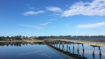 A bridge over a calm body of water with a clear sky.