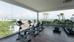 A gym with treadmills and elliptical machines, large windows with a city view. - Suria Next To Desa ParkCity (Kuala Lumpur)