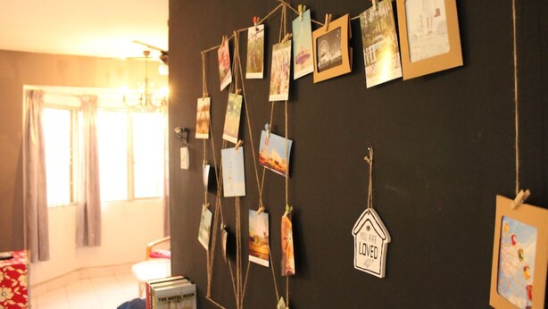 A room with a wall adorned with various photographs and a 'You are loved' sign. - Aman Dua Apartment by SYNC (Batu Caves)