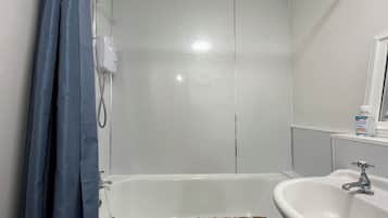 Un baño con bañera, lavamanos y ducha.