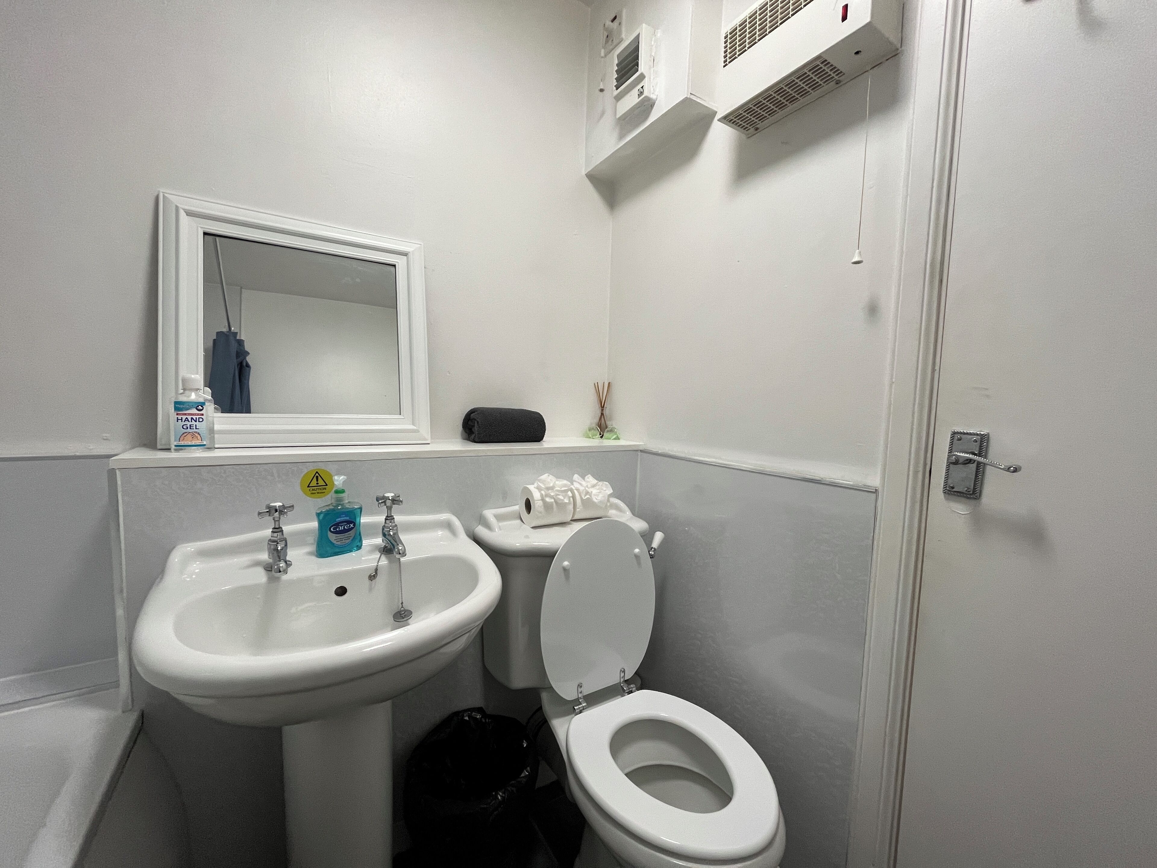 Un bagno con lavandino, wc e specchio.