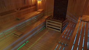 A wooden sauna with benches and a small wooden table.
