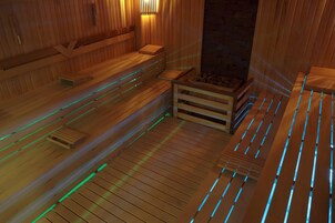 Una sauna de madera con bancos y una pequeña mesa de madera.