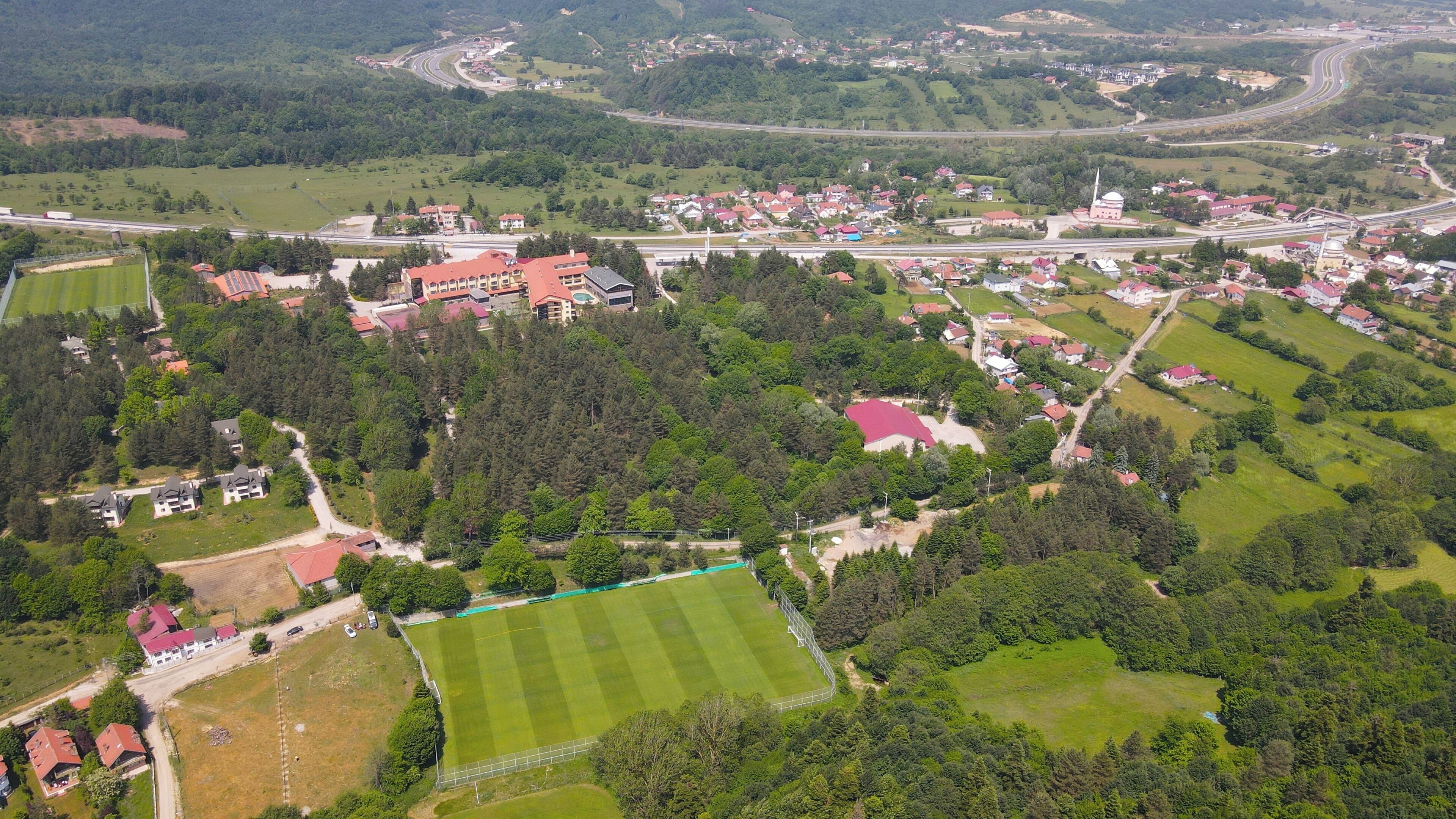 Vista aérea de un pueblo con zonas residenciales, un campo deportivo y una iglesia.