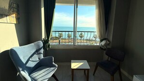 A room with a balcony overlooking the sea, featuring two chairs and a small table. - On Hotel (Antalya)