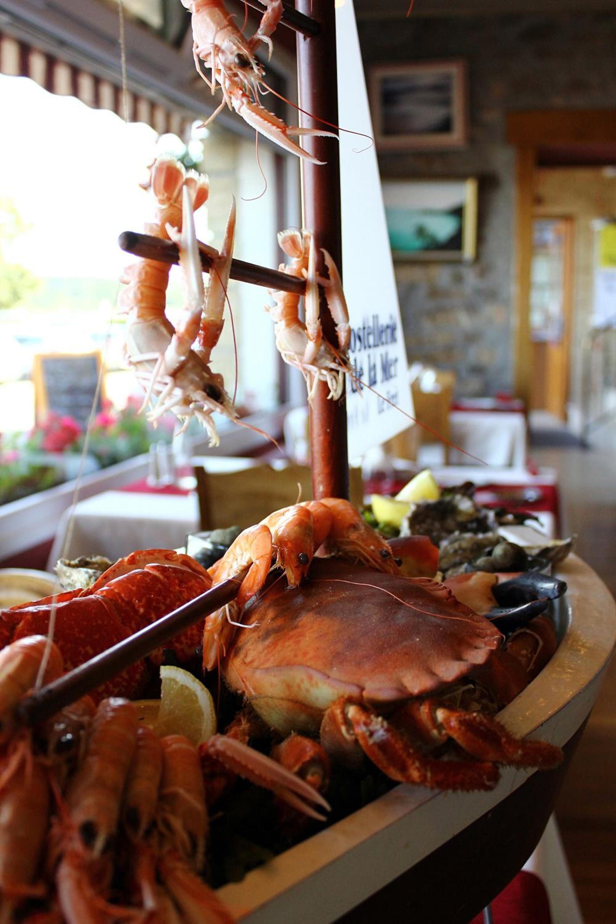 A seafood display with various types of shellfish and a sign indicating a seafood restaurant.