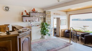 A modern kitchen with a wooden counter, a potted plant, and a view of the water outside. - Hostellerie de la Mer (Crozon)