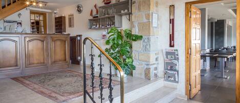 A spacious kitchen with wooden cabinets, a stone accent wall, and a staircase leading to a dining area.